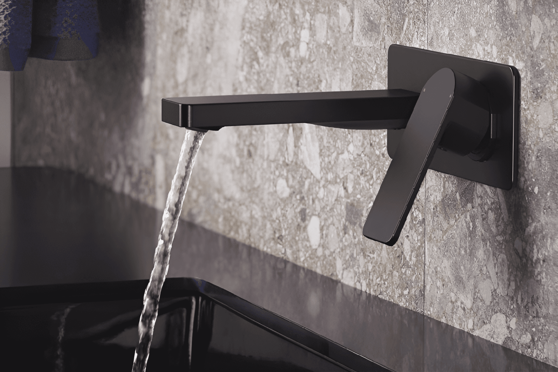 Chrome wall-mounted faucet over a countertop washbasin in a bathroom setting